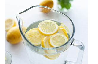 Water in pitcher with floating lemon slices.