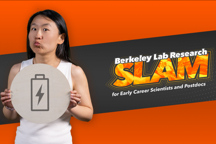 Researcher Jingbo Wang holds an illustration of a battery in front of the Berkeley Lab Research SLAM logo