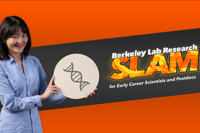 Researcher Ying Wang holds an illustration of DNA while standing in front of the Berkeley Lab Research SLAM logo