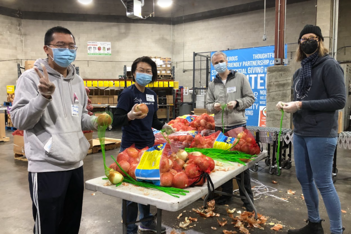 Four Berkeley Lab volunteers sort food at the food bank
