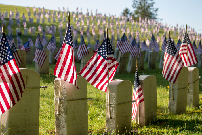 U.S. flags flying from headstones in a graveyard