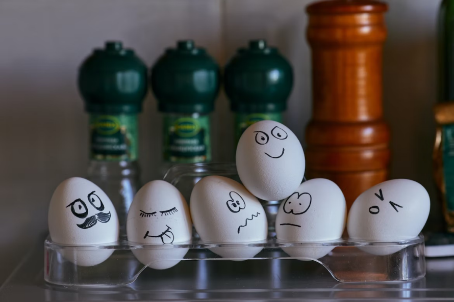 photo of six eggs with faces drawn on them