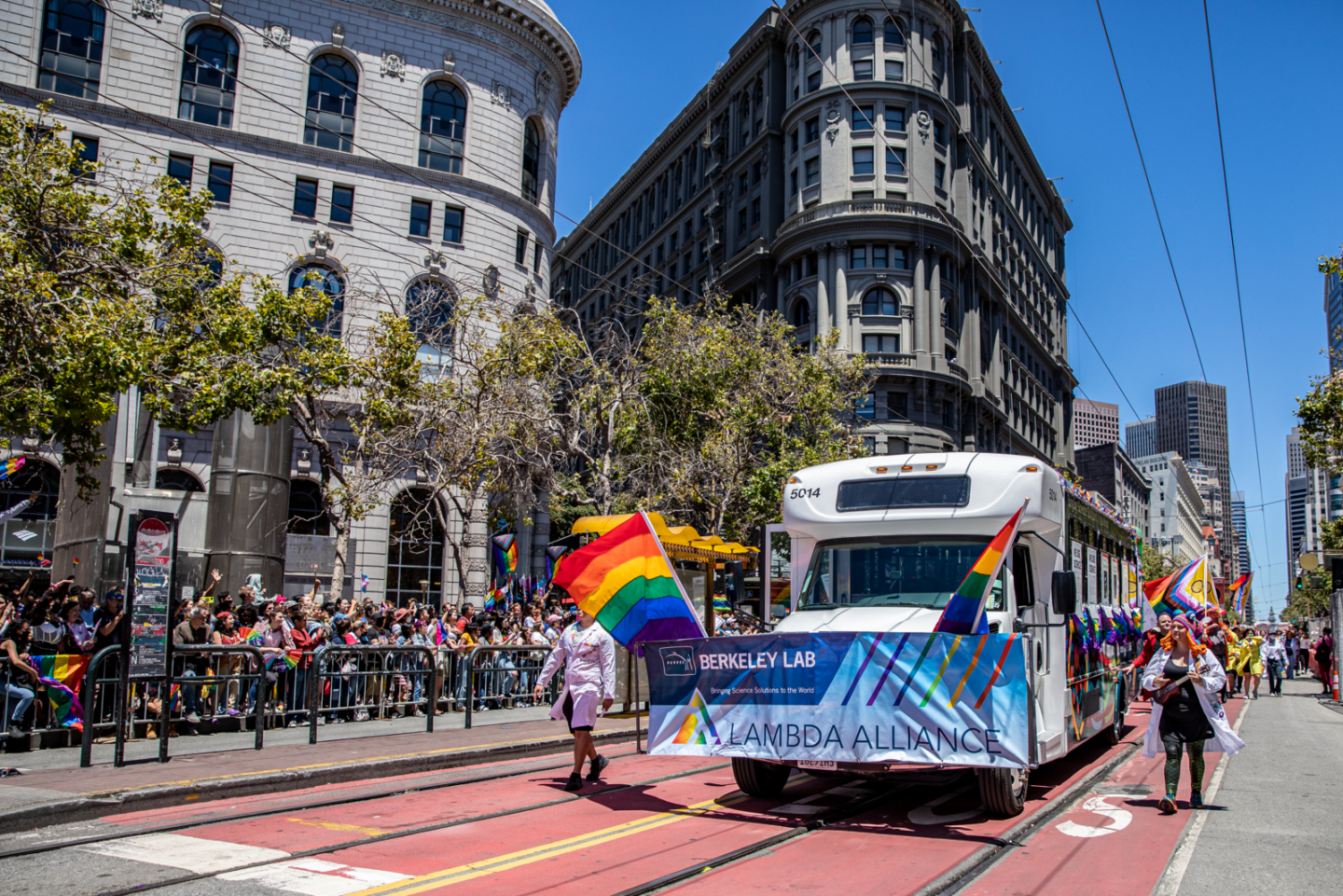 Decorated Lab shuttle and Pride marchers on Market St in San Francisco