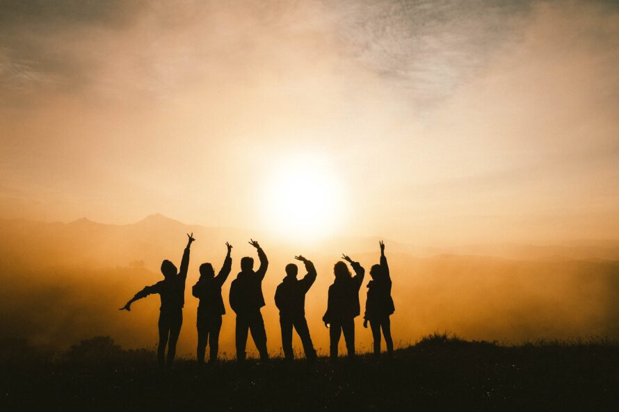 People on a hike with their arms raised