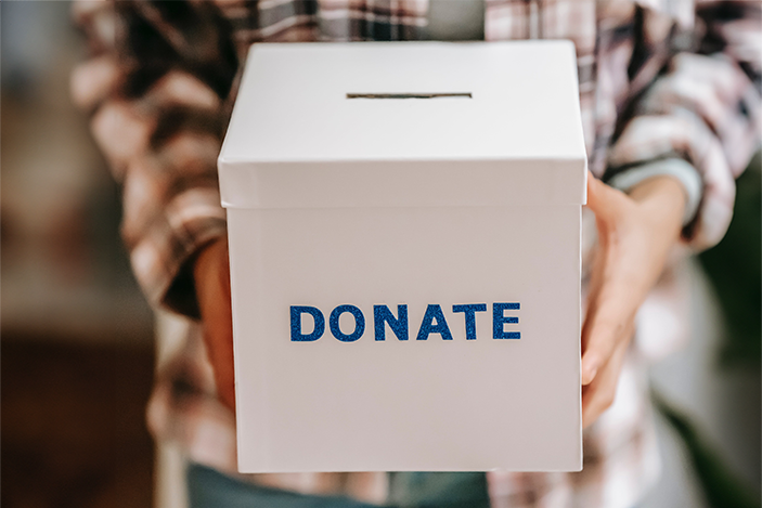 hands hold a box with Donate written on the front