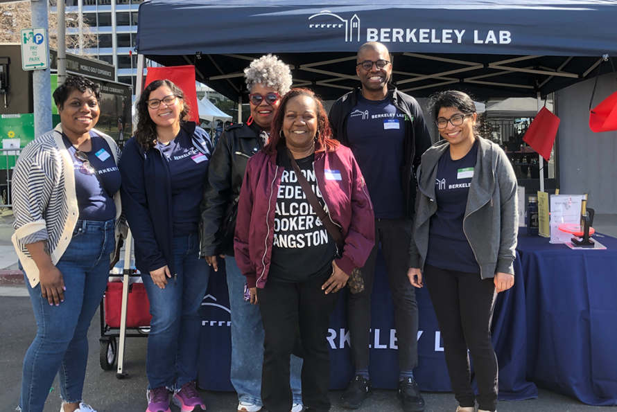 Lab volunteers stand in front of the Berkeley Lab booth at the 2024 Black Joy Parade in Oakland CA
