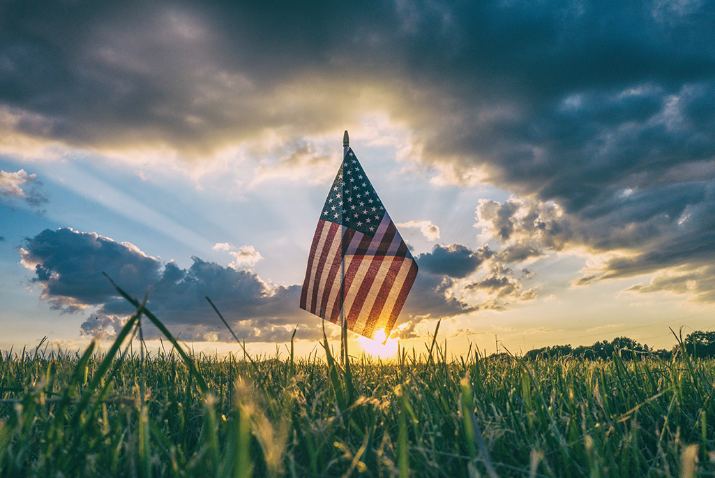 US flag shown in field against a rising sun