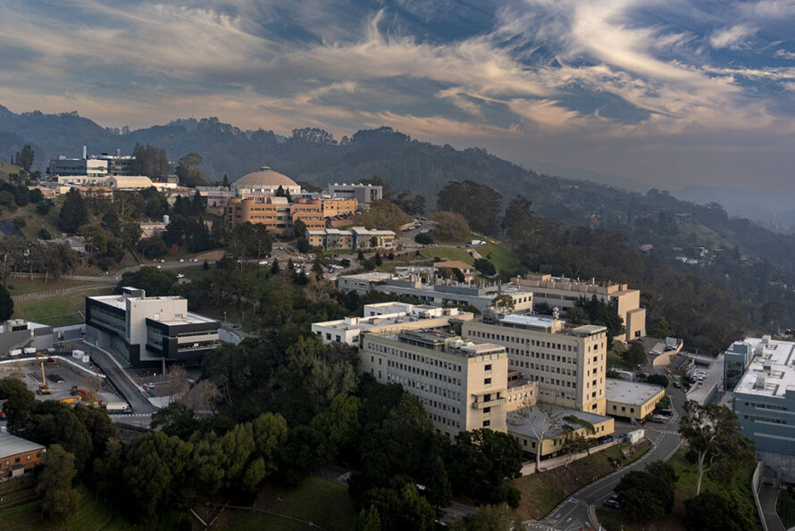 Collection of buildings on hills side in daylight with clouds in the sky