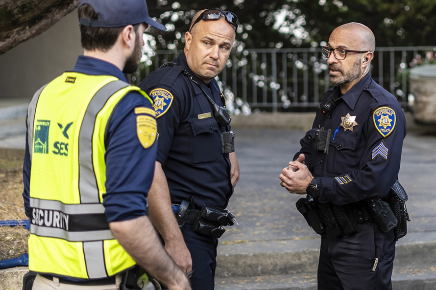 Photo of two police officers speaking with a Lab security staff member during an emergency exercise.