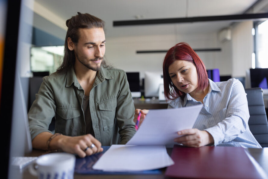 Two persons sitting at a table reviewing a document