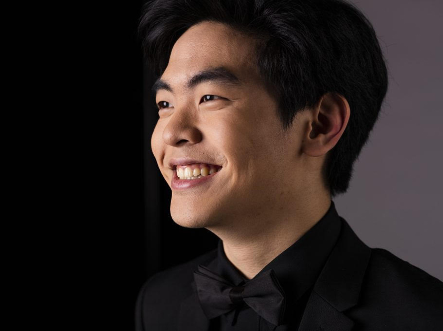 Headshot photo of pianist Daniel Hsu smiling and wearing a black shirt.