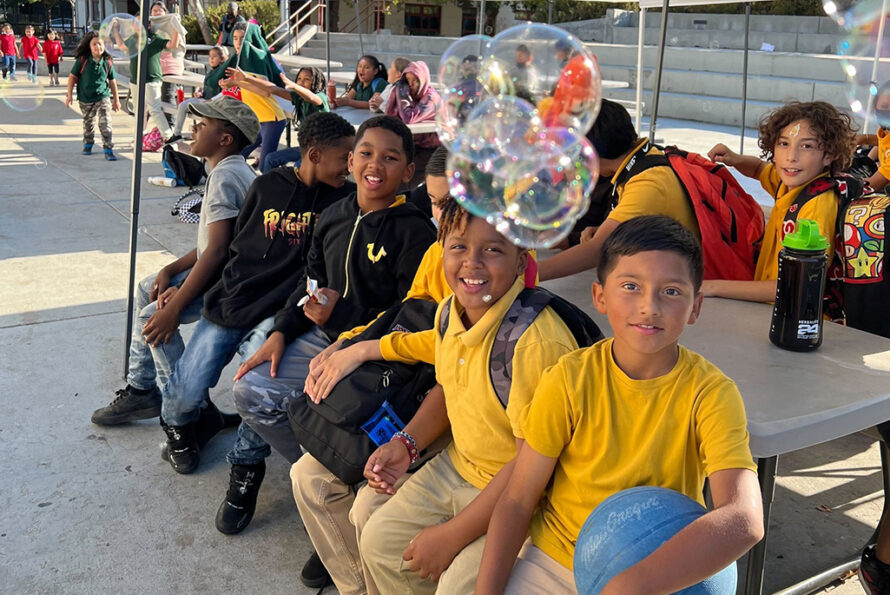 Group of young people sitting outside looking at camera