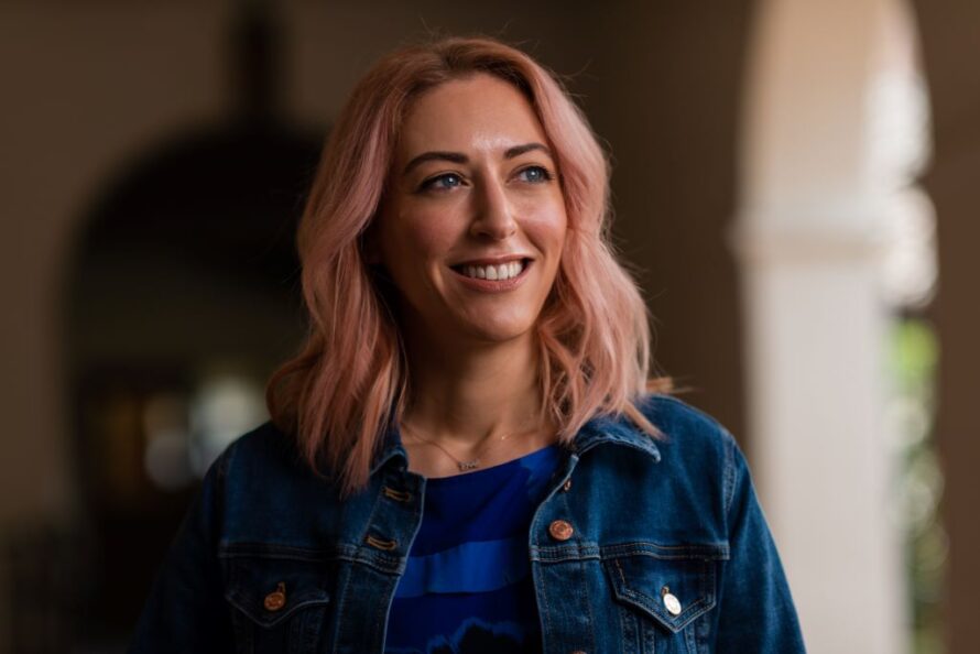 Photo of person smiling with building arch in background