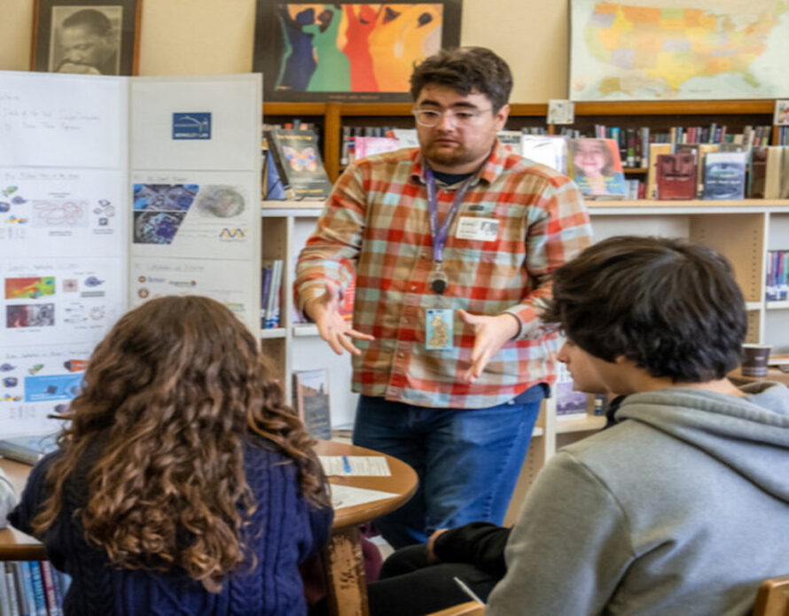 Person presenting science project to group of seated persons