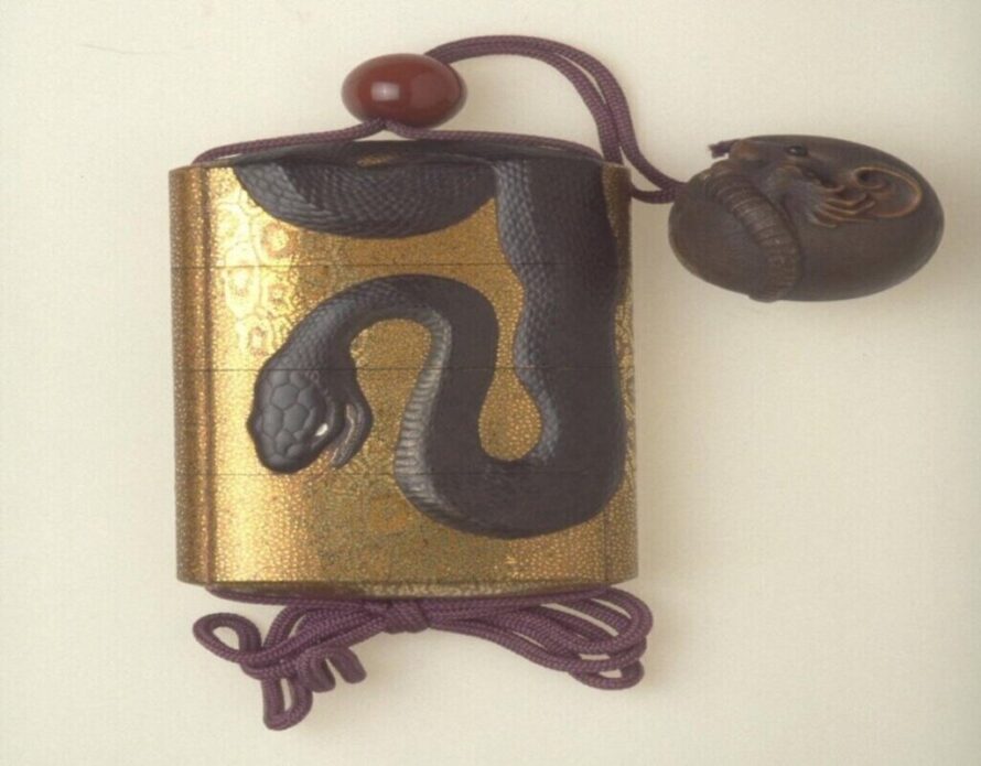 Gold Asian ancient jewelry with black snake on front