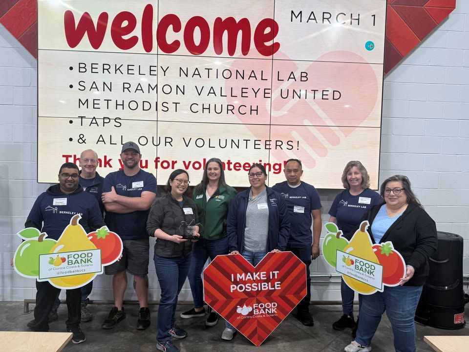 Group of persons holding red sign in front of them with the words " welcome" and "Thank you for volunteering"