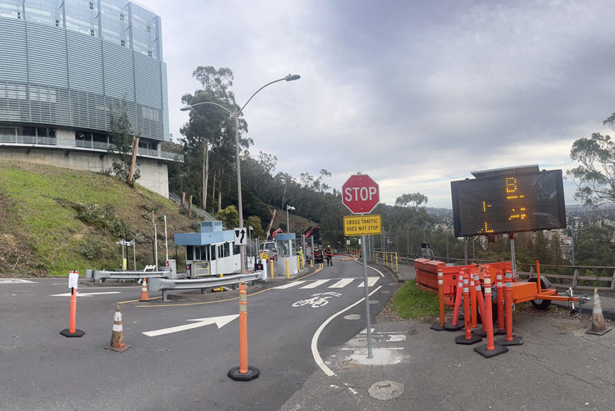 Entrance to commercial setting with gatehouse and orange traffic sign