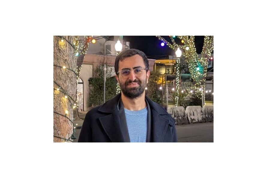 Headshot of person at night with ornamental lights in background.