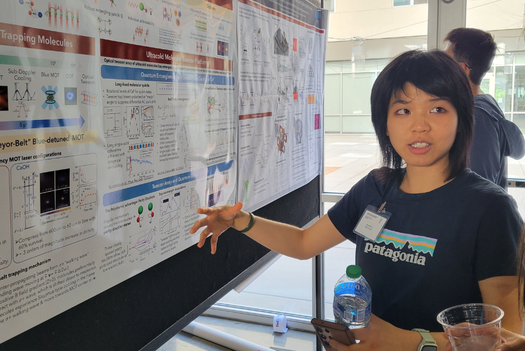 Person standing in front of poster board pointing toward it.
