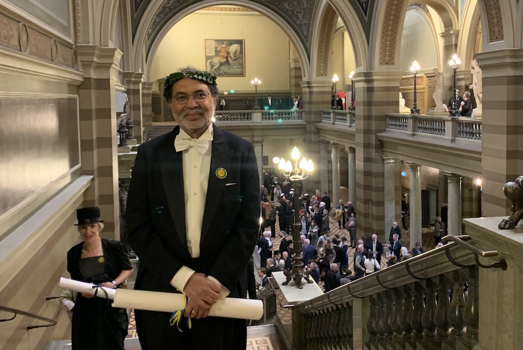 Person holding paper scroll on staircase in opulent building.