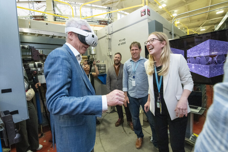 Person with virtual reality headset on with other people observing.