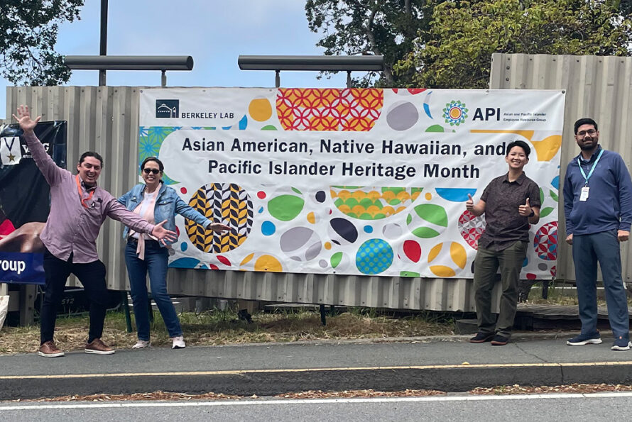 Group of persons standing in front of banner with words Asian American, Native Hawaiian, and Pacific Island Heritage Month.