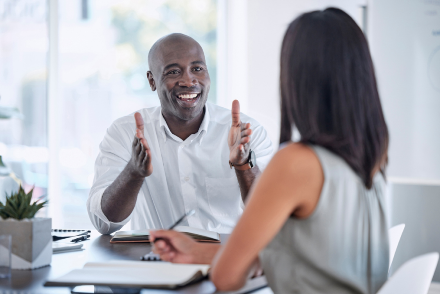 Man and woman having lively conversation at a desk