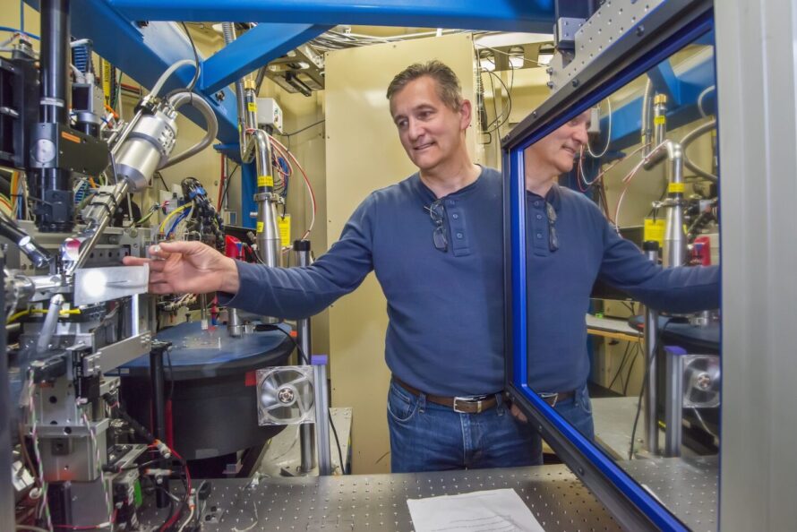Person in blue shirt adjusting scientific equipment