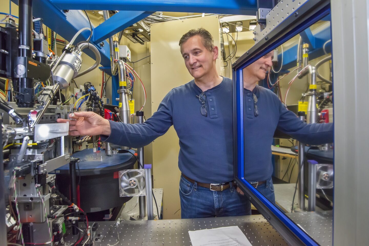 Person in blue shirt adjusting scientific equipment