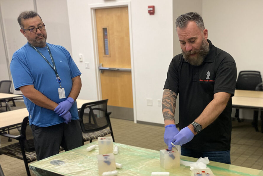 One person in black demonstrating stop bleed technique