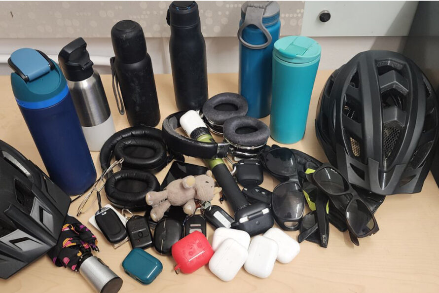 Water bottles, glasses, earbuds, bike helmets on table
