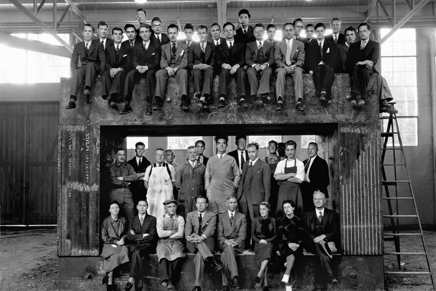 History black and white photo of two rows of people sitting on a large magnet.