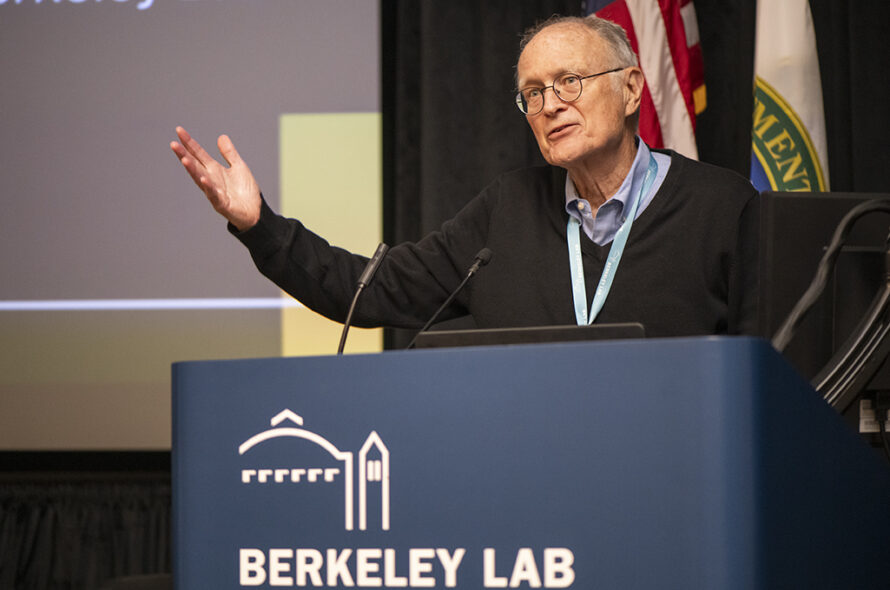 Person stands at a lectern in front of auditorium