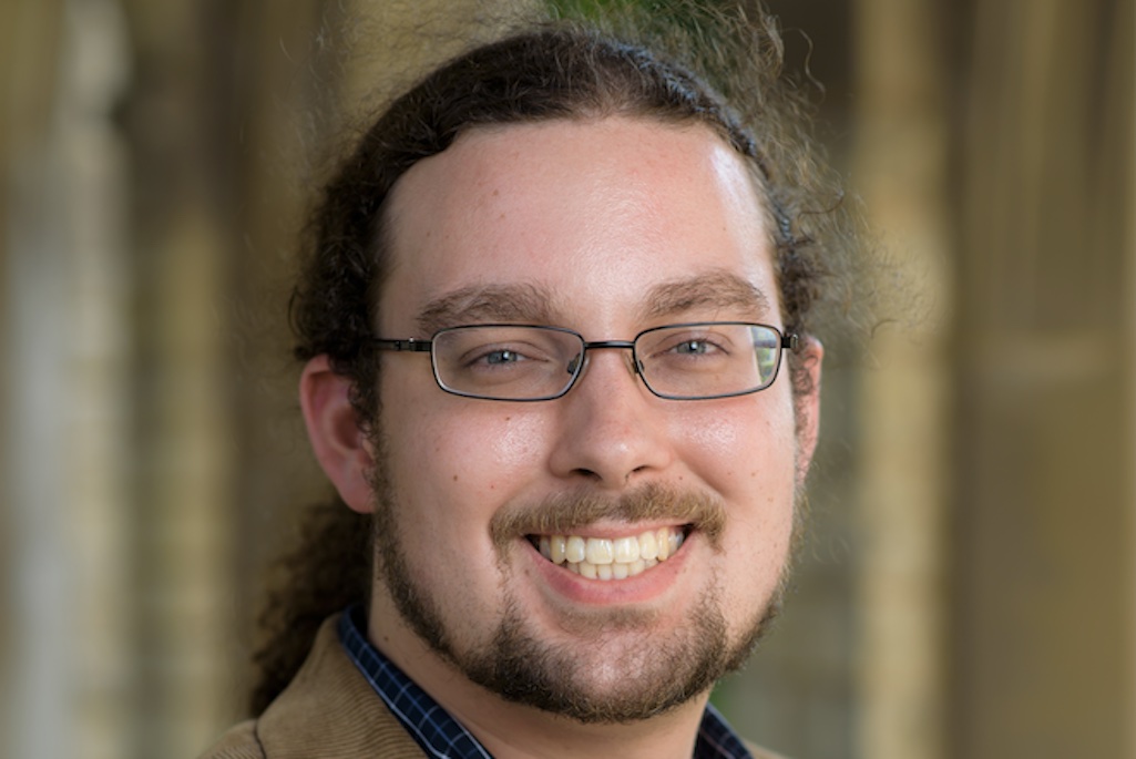 Headshot of person wearing glasses and smiling.