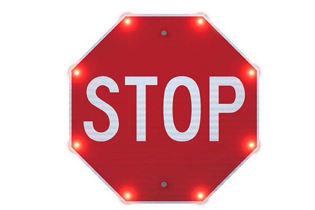 Red octogon sign with text stop surrounded by flashing lights