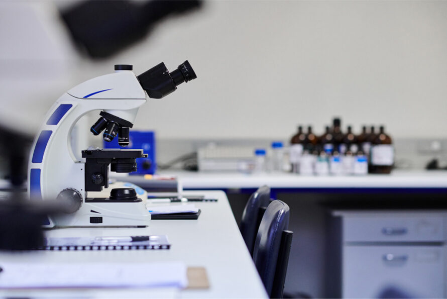 Close up of microscope in an empty lab space.