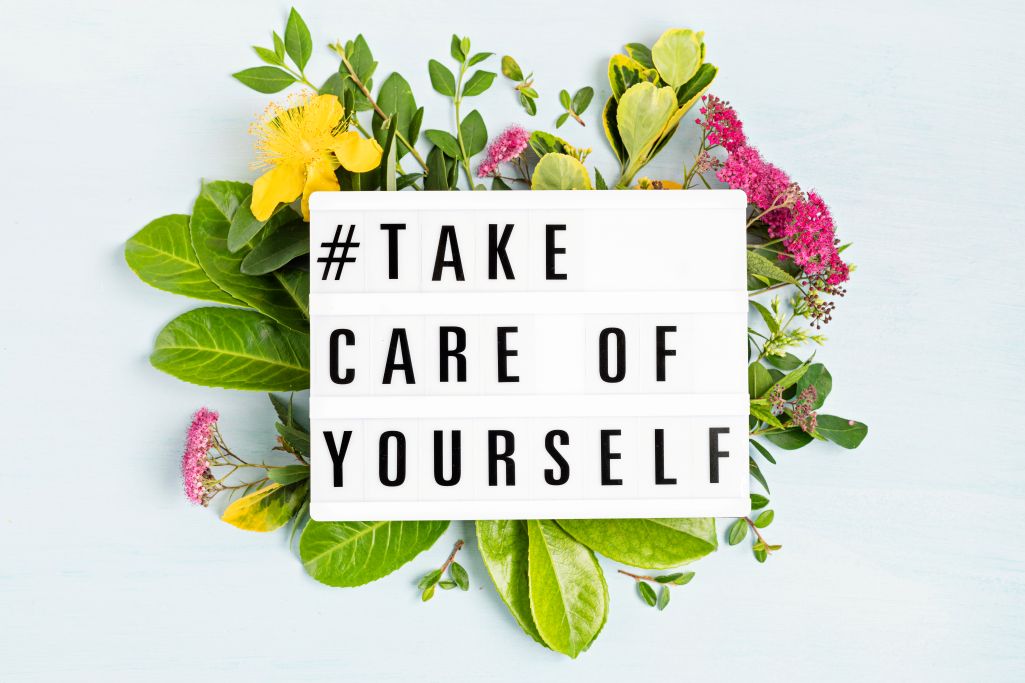 Bouquet of yellow and pink flowers overlaid by white text block reading "#Take Care of Yourself"