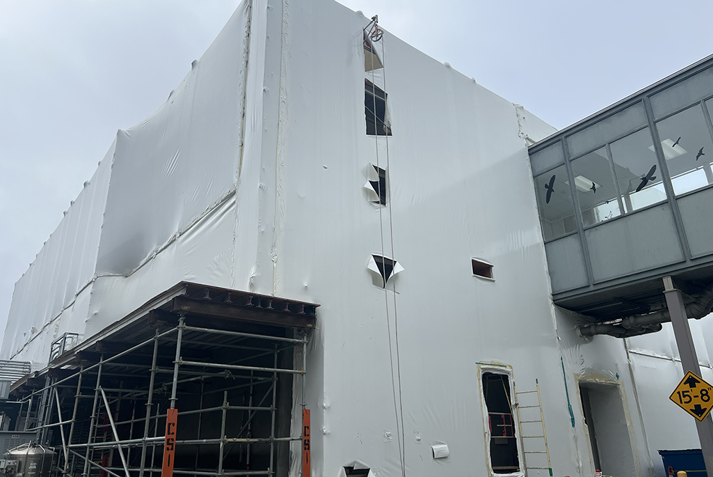Exterior of multi story building with white wrapping around it