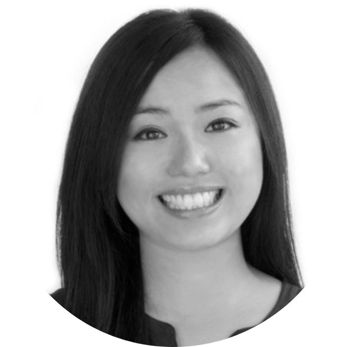 Black and white portrait of person with long hair, smiling.