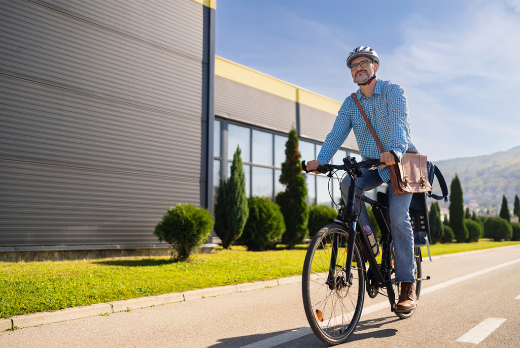 Person commuting to work on an e-bike, wearing a helmet.