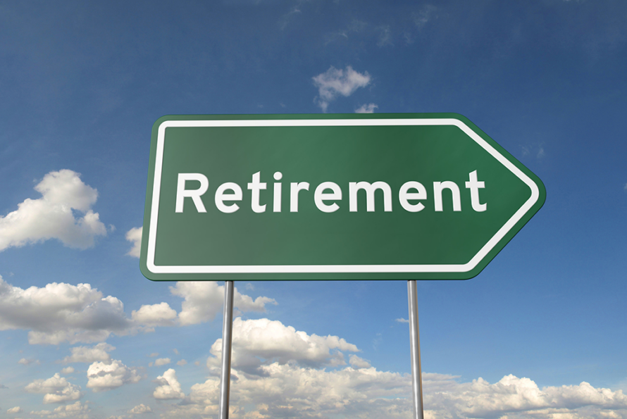A green road sign that says "retirement" against a blue sky