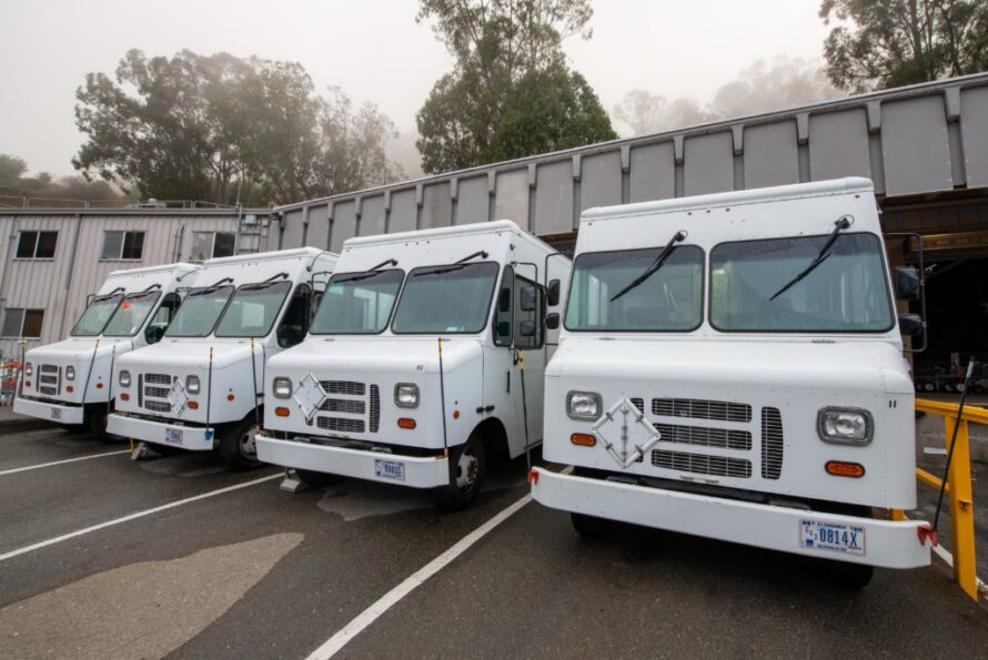 Four white trucks parked next to each other at Berkeley Lab’s Shipping & Receiving facility.