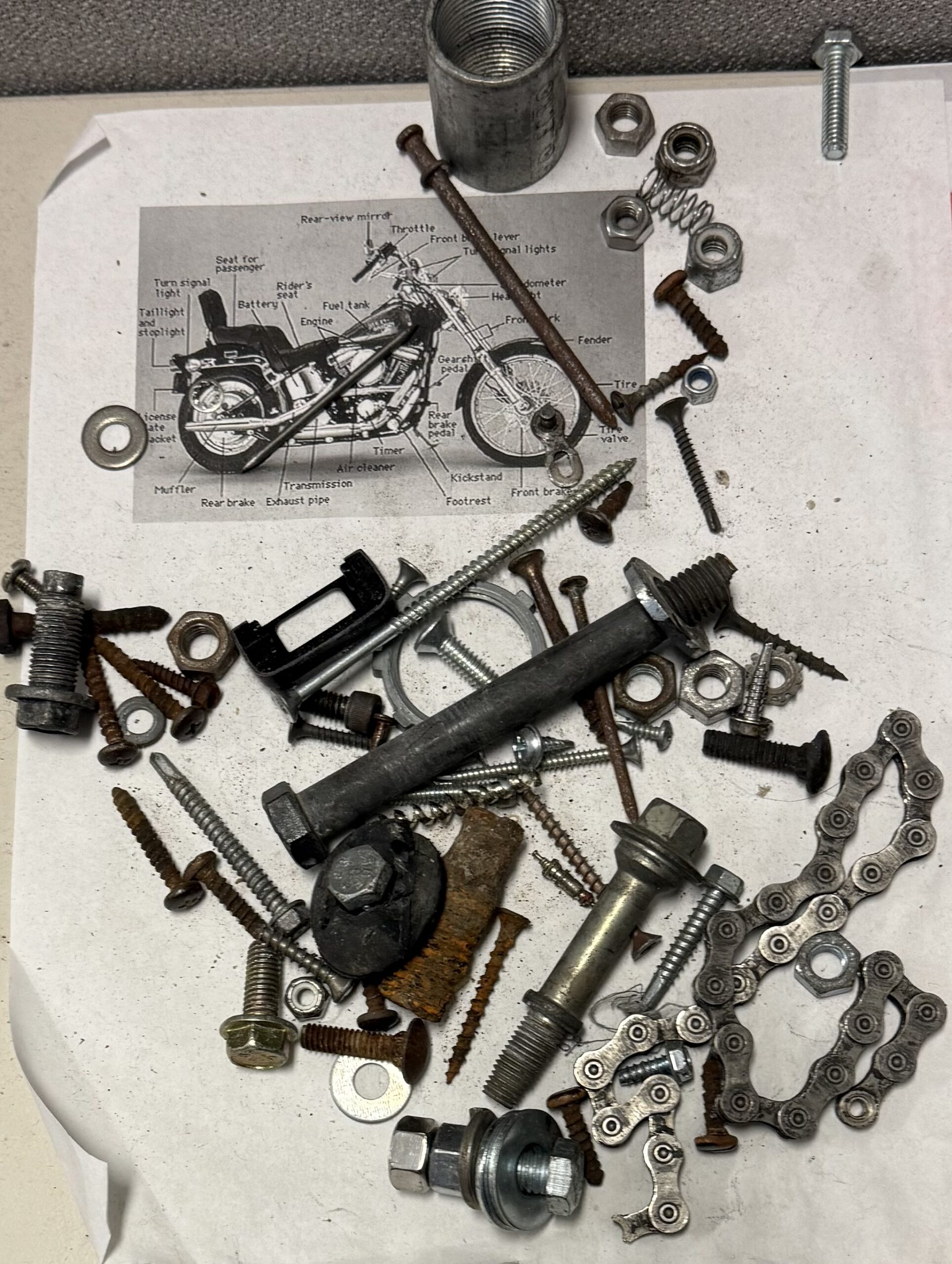 collection of metal screws and nails over an image of a motorcycle
