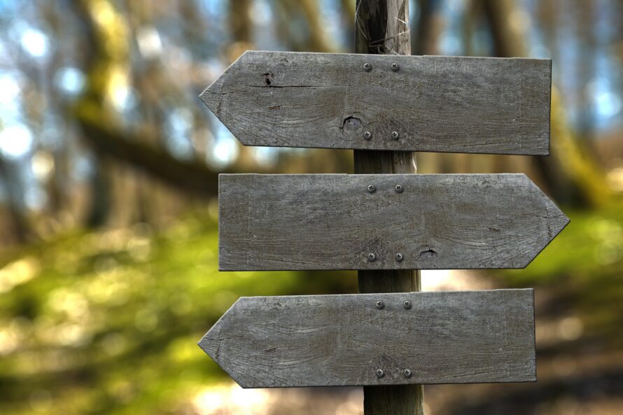 Wooden signpost with three directional signs