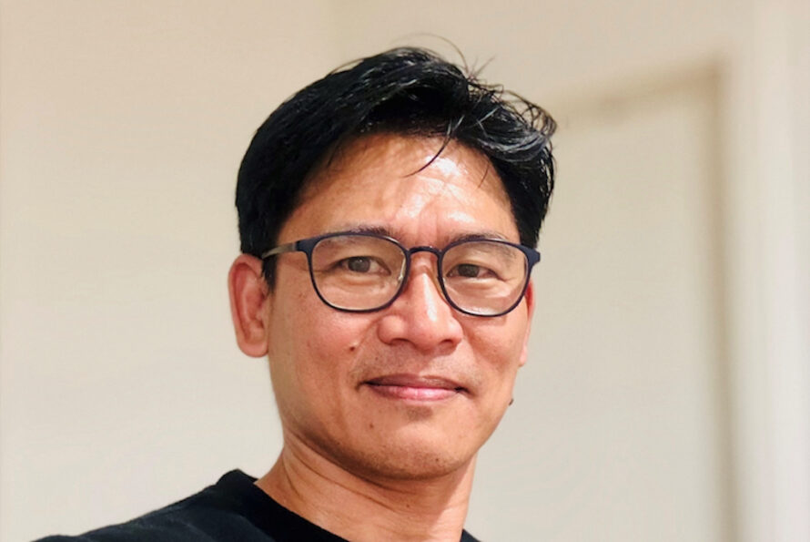 Person with dark hair and glasses
