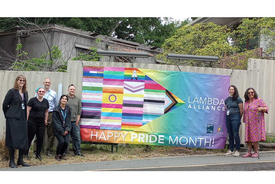 Group of people standing outside in front of a banner
