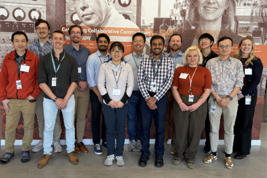 Group of standing persons smiling with historical science scenes in background