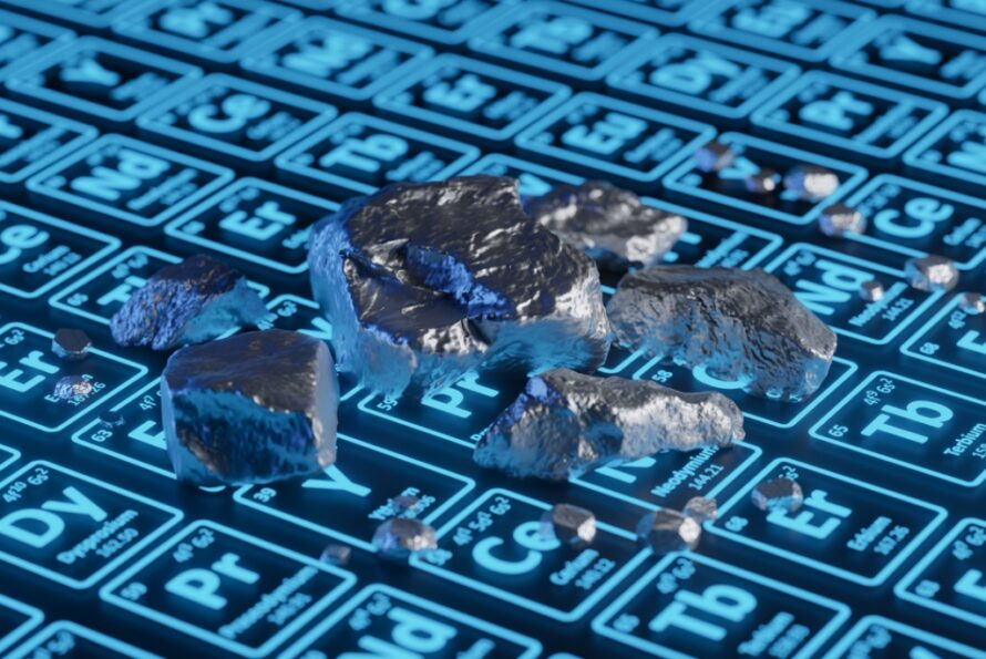 Silver metallic material sitting on top of a periodic table of black and blue element tiles