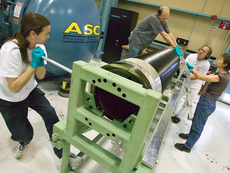 Four members of Berkeley Lab's ATLAS project engineering team assemble the carbon fiber support tube for the ATLAS Pixel Detector.