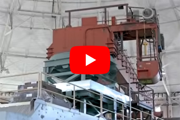 Large machinery with video play button on top of image